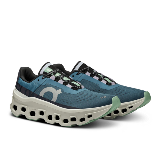 Angled lateral view of a pair of Women's dark green On Cloudmonster with light gray sole
