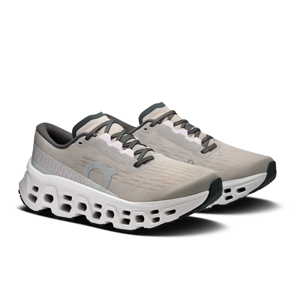 Pair of gray running shoes with white sole on a white background
