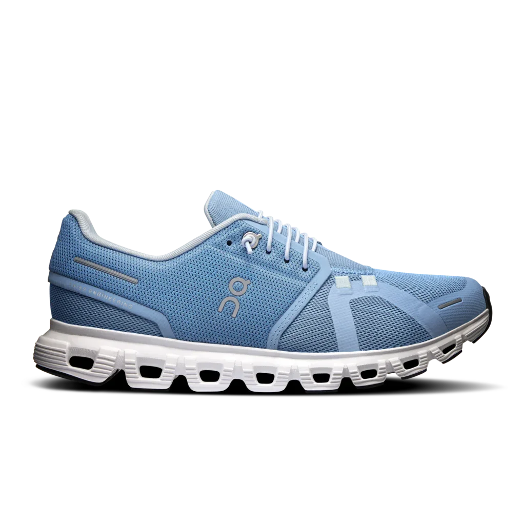 Blue running shoe with white sole on a white background