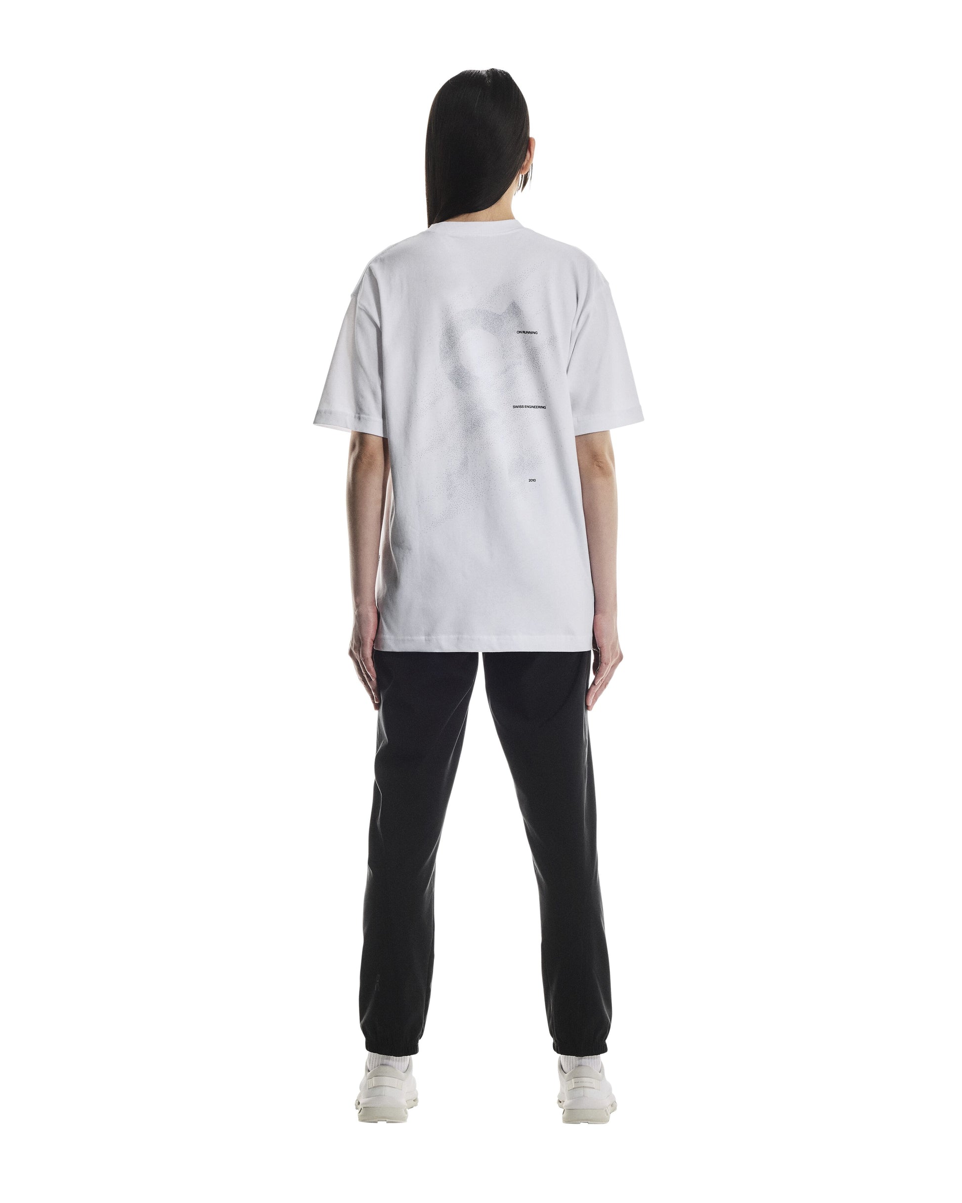 Rear side of Person wearing a white t-shirt and black pants on a white background