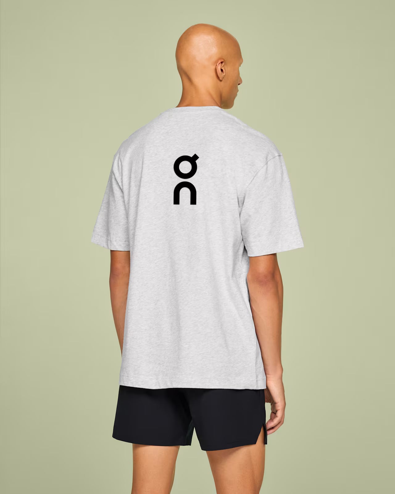 Rear view of white t-shirt on model with logo on the back